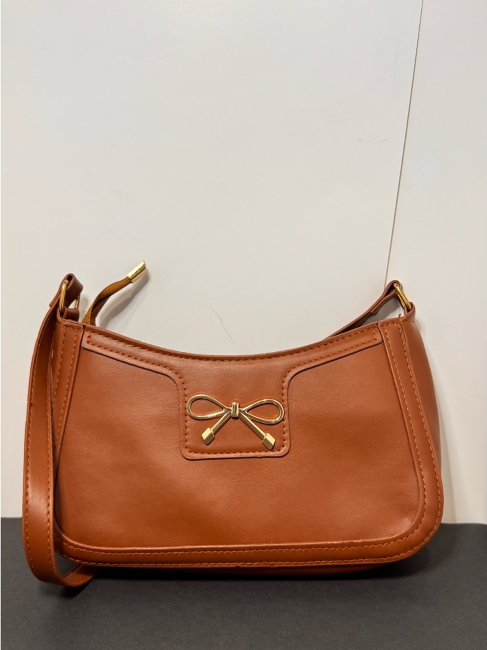Sleek Tan Shoulder Bag with Gold Bow Accent